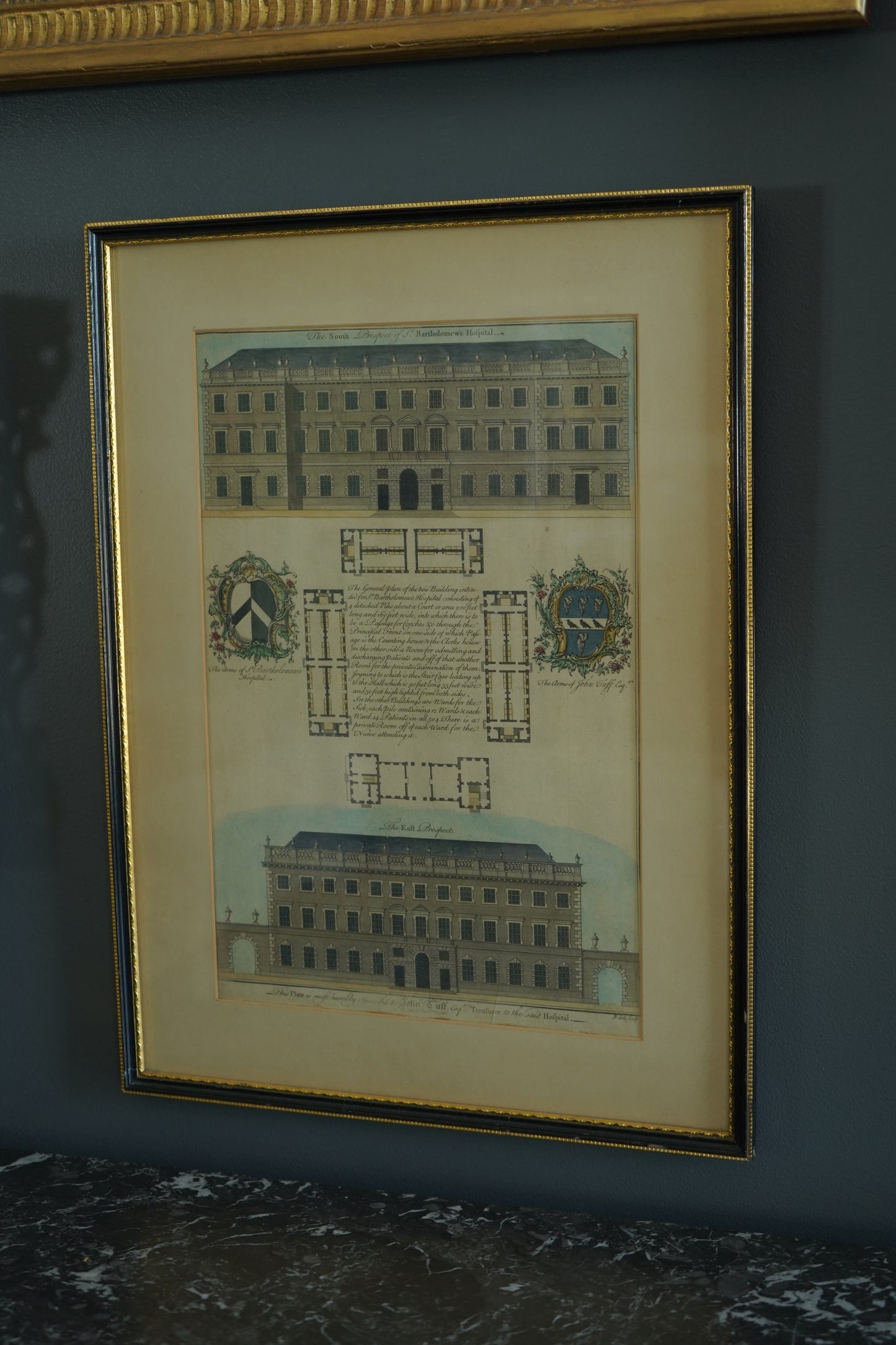 Framed architectural drawing of a building on a wall