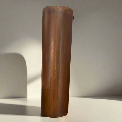 Wooden cylindrical object held by a hand 