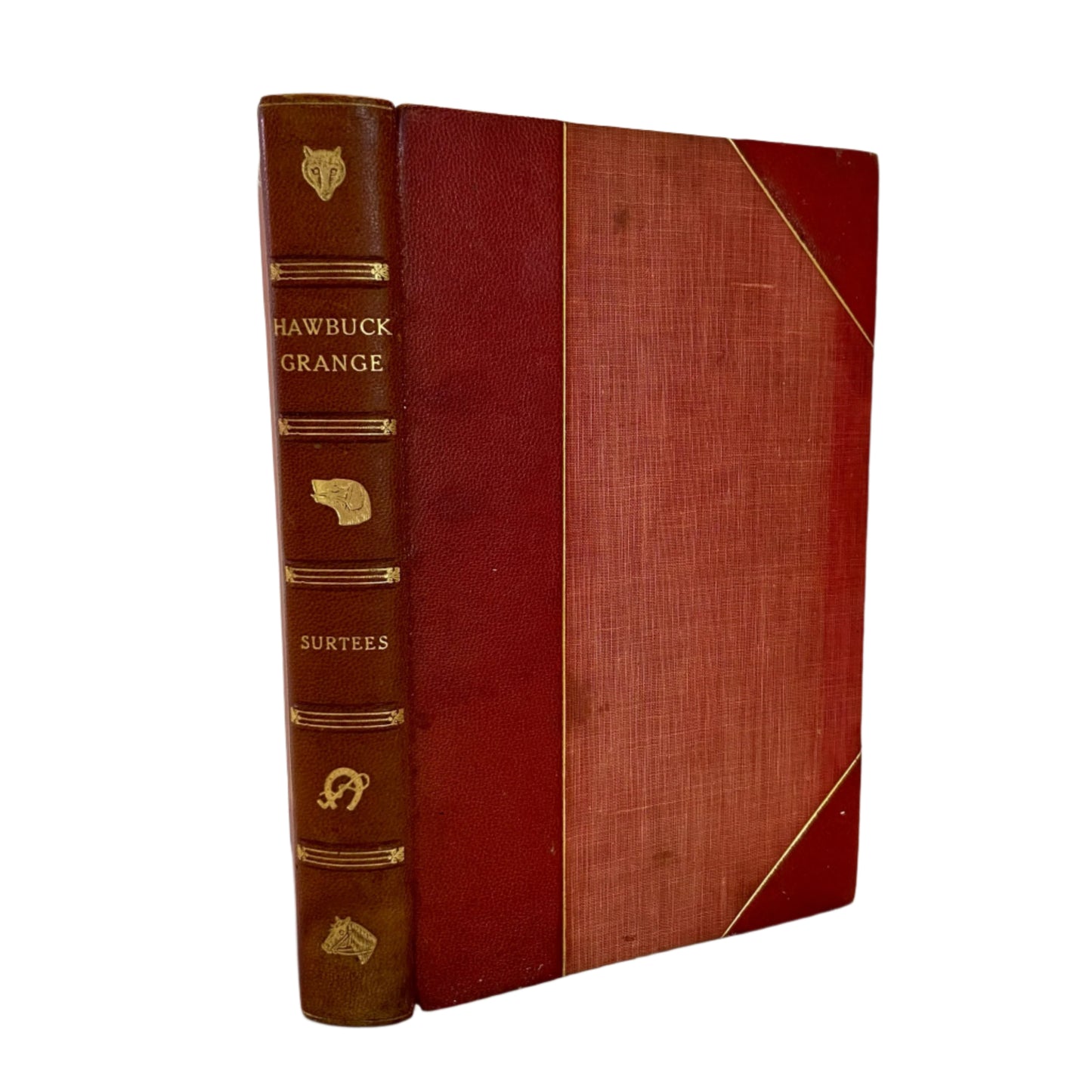 An 1847 edition of 'Hawbuck Grange' with half red leather binding and decorative gold details on the spine.