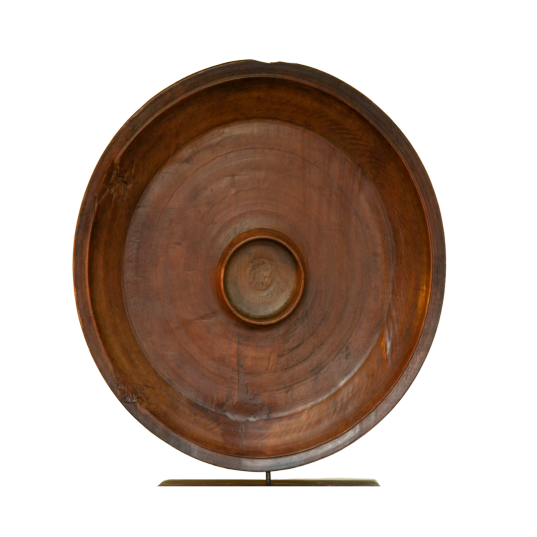Wooden bowl mounted on a cast metal display stand on a white background
