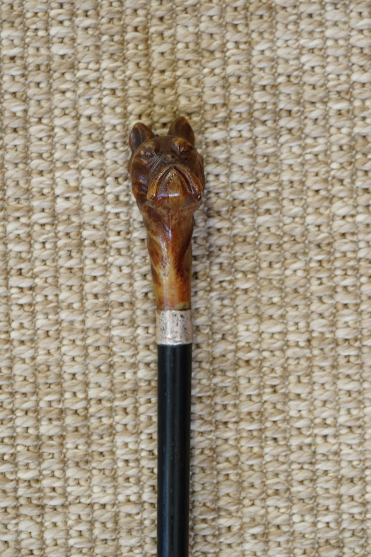 Decorative cane with a wooden handle on a textured beige surface