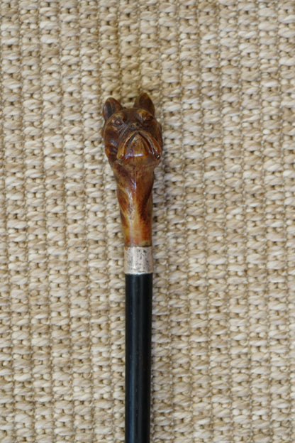 Decorative cane with a wooden handle on a textured beige surface