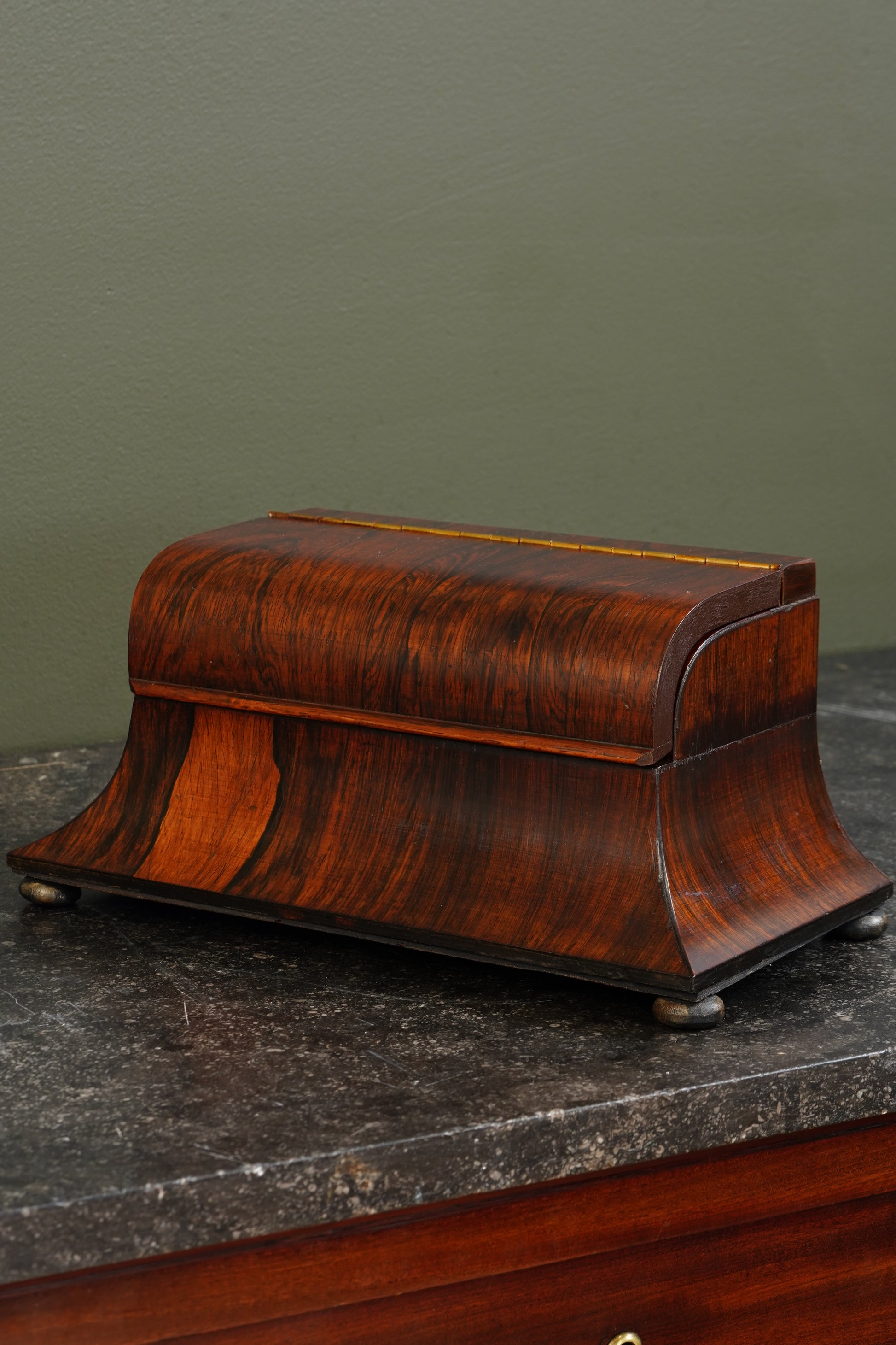 Wooden jewelry box on a dark surface with a green background