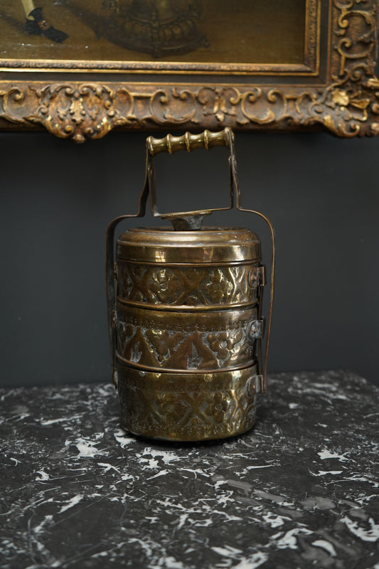 Decorative metal object with intricate designs on a dark background
